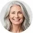 A circular profile headshot of Susan M., a smiling senior woman with long, elegant gray hair and a bright, friendly expression.